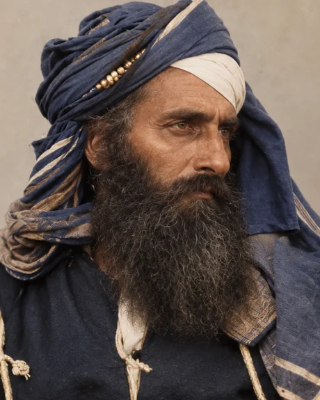 Diwan Mulraj of Multan in a dark blue turban with a gold ornament, a dark robe and a long greying beard