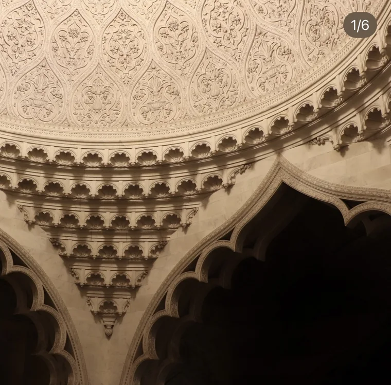 Detail of the Elveden dome: carved floral plasterwork above tiers of muqarnas brackets stepping down to a cusped arch