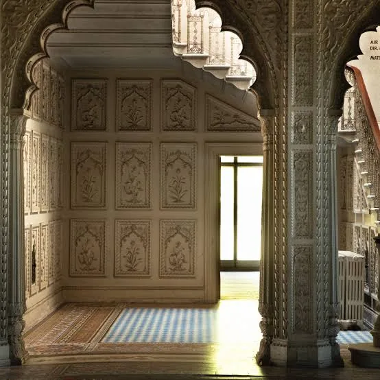 Interior of Elveden Hall showing carved Mughal-style arches, columns and floral relief panels in the Lahore manner