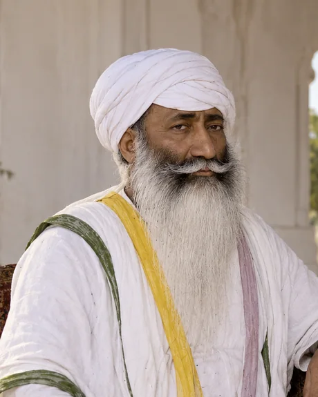 Sham Singh Attariwala, an elderly sardar seated in plain white robes with a white turban and long white beard