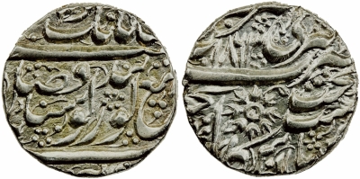 Amritsar, VS1863, Bershahi Rupee
Stephen Album Rare Coins | Auction 29
AR arsiwala rupee (11.15g), Amritsar, VS1863, KM-20.6, pipal leaf replaced by flower-like symbol, well centered & strike example, single testmark on edge only, Almost Unc to Unc., ex Hakim Hamidi (Persic Gallery). The so-called Arsiwala symbol is said to represent a flower of the Dukh-Bhanjani Beri (Jujube) tree in the Golden Temple in Amritsar.
